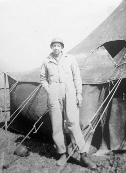 Photograph showing Corporal Jerome J. Lawrence posing in front of a Pyramidal Tent at the 11th Evacuation Hospital.Photo courtesy of David Lawrence.