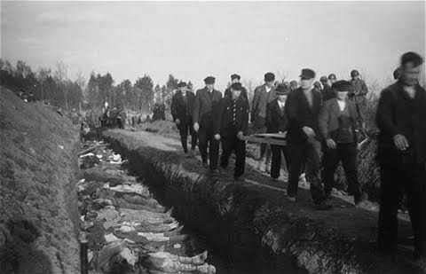 Vintage photo illustrating burial of Dora-Nordhausen Concentration Camp victims after the Camp’s liberation 13-14 April 1945. German civilian and military authorities were compelled to help with recovery and burial operations and forced to pass by the mass graves to witness the horrible and tragic death of the many inmates by the Concentration Camp authorities. The 3d Hospitalization Unit, 51st Field Hospital, set up a temporary Surgical Hospital in the Camp between 12-17 April 1945 to help alleviate the suffering and offer treatment and care to the survivors.