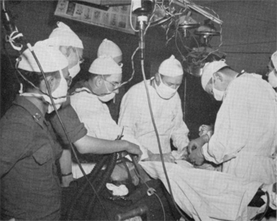 Photo illustrating an Operation Room with surgery going on, probably taken around mid-June 1944, following opening of the 51st Field Hospital in Normandy, France, on 11 & 12 June 1944.