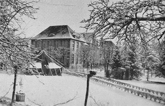 Front view of the 34th Evacuation Hospital at Metz, France. The organization took over buildings formerly occupied by the Wehrmacht and used as a military hospital during their occupation of France. Photograph taken in the winter of 1944-45. 