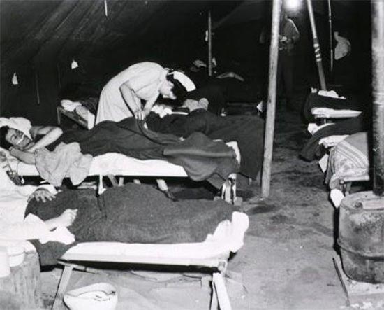 Vintage photo illustrating a Nurse at work in a Ward Tent. Photo taken March A944, at Bucciano, Italy, where the entire 11th Field Hospital was established between 9 and 11 March 1944.