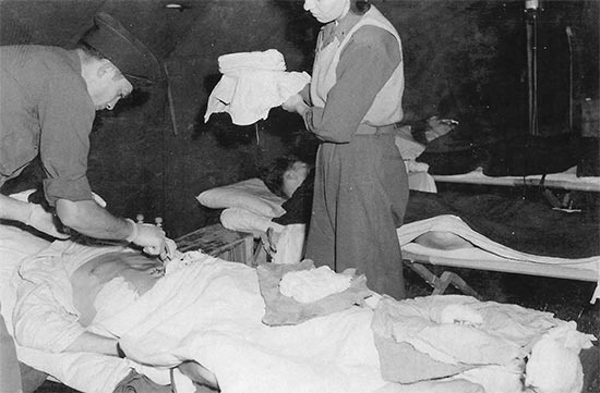 Vintage photo illustrating medical personnel pertaining to Unit I, 11th Field Hospital, at work. Photo taken early October 1944 in Alsace, France.