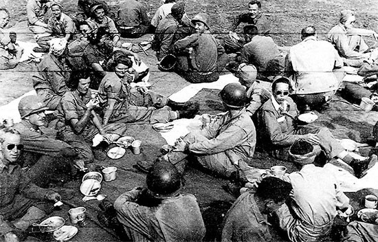 June 1-6, 1944. Picture of 56th Evacuation Hospital personnel having chow on the ground, while stationed at Fondi, Italy.