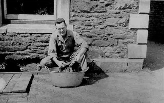 Photo illustrating Technician 5th Grade Stephen M. Benton, Fourth Platoon, 607th QM GR Co, washing some clothes, while being stationed at Camp Knowle, Bristol, England